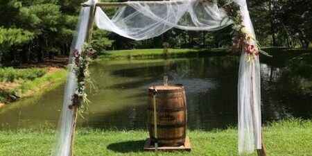 Outdoor wedding arch by a pond.