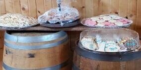 Cookies displayed on barrels beneath happiness sign.