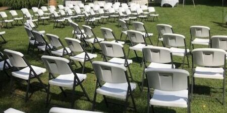 Outdoor event setup with chairs and tents.