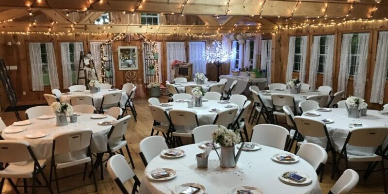 Rustic indoor wedding reception with round tables.