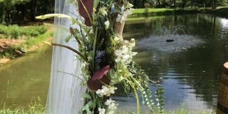 Floral arrangement by pond with fountain.