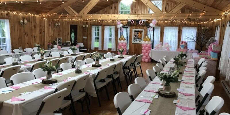 Rustic event hall with decorated banquet tables.