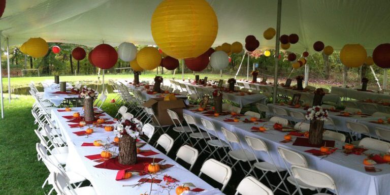Outdoor event with decorated tables and lanterns.
