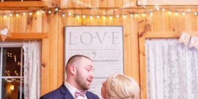 Wedding couple dancing in rustic decorated venue.