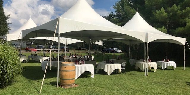 Outdoor event tents with tables and chairs.