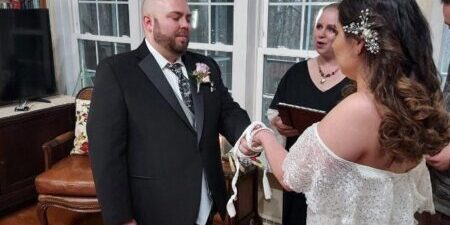 Couple exchanging vows in living room ceremony.