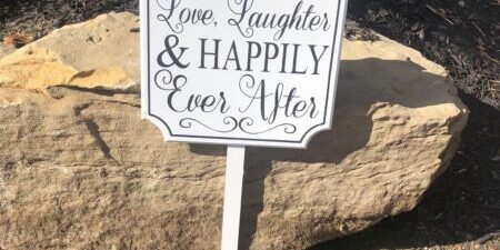 Wedding sign on ground near stones.