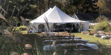 White event tent in a garden setting.