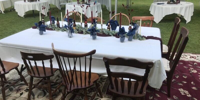 Outdoor dining setup with wooden chairs and tables.