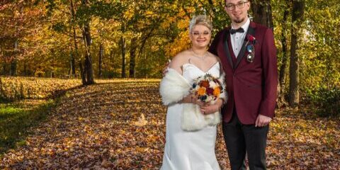 Bride and groom in autumn forest setting.
