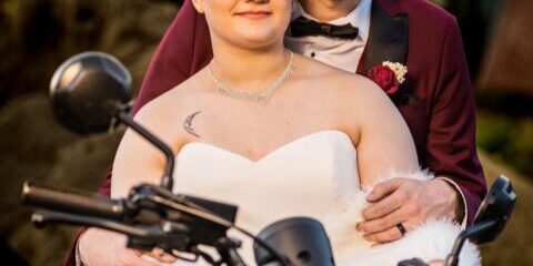 Bride and groom on a motorcycle.