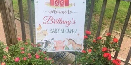 Baby shower sign with floral decorations.